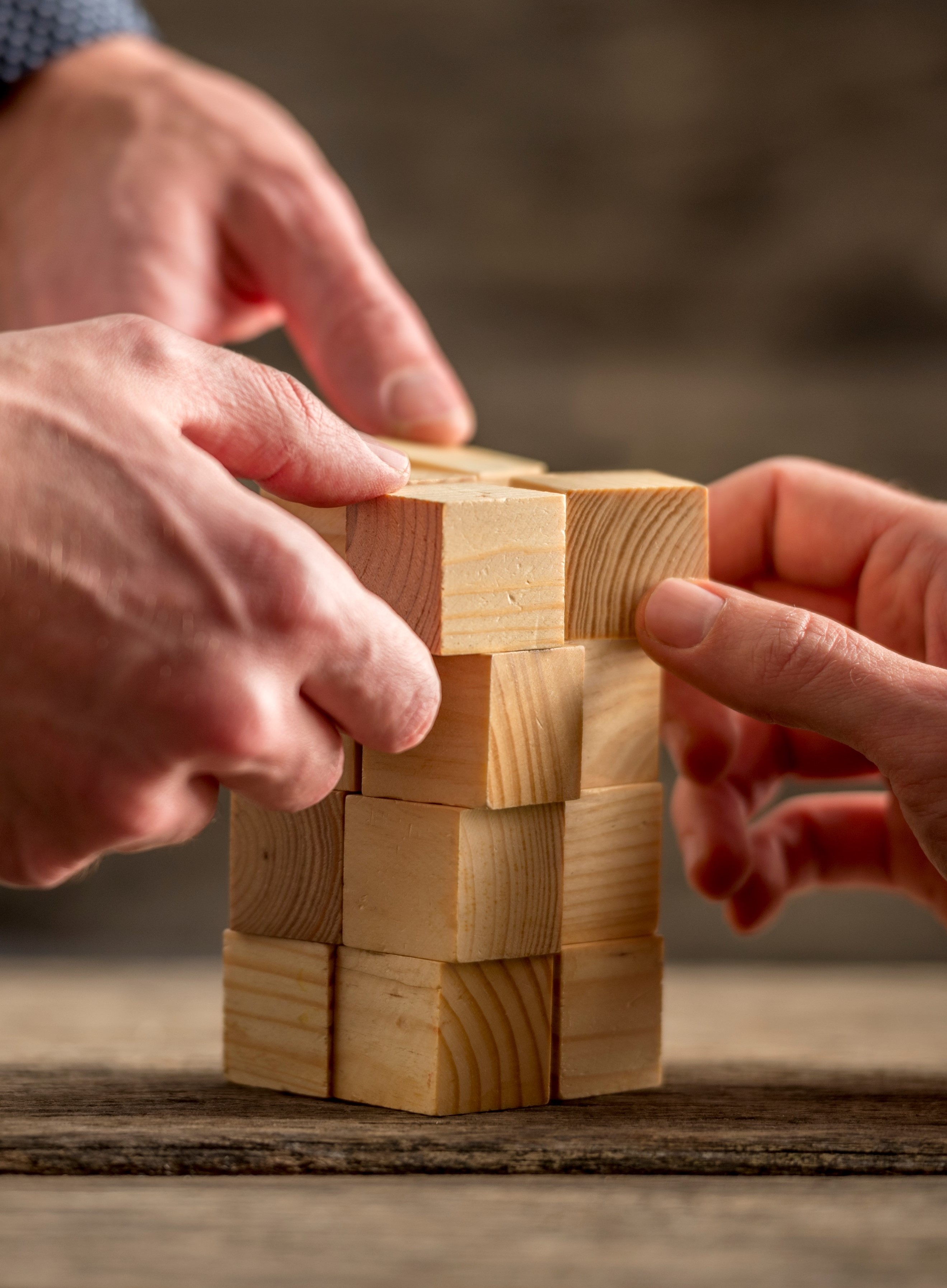 CORP SITE MISSION2.jpg (Hands building a tower of wood blocks)